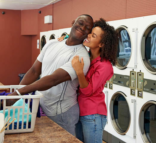 Couple doing laundry at laundromat